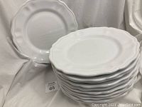 Stack of 11 white ceramic pasta plates with scalloped edges, showing the lot quantity and general condition.