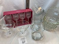 Photo showing full set with boxed Crystal D'Arques shot glasses, uncovered sherry glasses, old fashioned glasses, and stacked Pyrex bowls