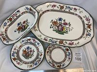 Overview of the oval serving platter, oval vegetable bowl, and two saucers showing detailed floral patterns and color scheme.