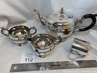 Photo showing all items in the lot including teapot, creamer, sugar bowl, and baby cup next to a ruler for size reference.