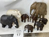 Full view of the seven elephant figurines showing different materials and sizes.