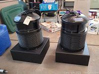 Two FilterQueen Defender units side by side on stands in garage setting