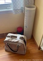 Carrying bag for the Singer Imperial sewing machine placed on wooden floor near vent and window