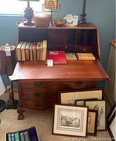 Front view of closed dropfront desk showing serpentine drawer fronts and hardware