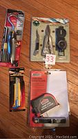 Photo showing all assortment items: flexible lighter, Bahama Pro utility knife, Jobmate laser level, sportsman pack with knife, pliers, compass, and multi-tool.