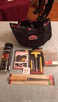 Full view of lot contents showing 3M spray adhesive, wireless LED lights, screwdriver set, drywall saw, drill bits, and Jobmate tool bag.