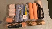 All 12 paint rollers laid out showing various sizes, textures, and packaging states.