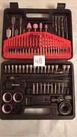 Full overview of kit in black plastic carrying case showing drill bits, sanding cylinders, sockets, and accessories in organized compartments