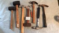 Full view of all eight hammers laid out on a surface showing different types and conditions