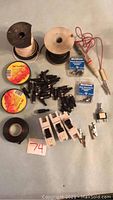 Full lot overview showing wire spools, electrical tape rolls, circuit breakers, alligator clamps, continuity tester, connectors and switch