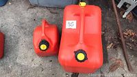 Photo of two red plastic gas containers, one large and one small, showing the front and top sides with caps and handles visible.