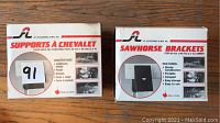 Front view of original packaging for the set of sawhorse brackets, showing branding and features in English and French.
