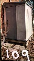 Front view showing double doors with padlock latch and base