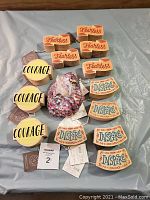 Photo showing 3 'Courage' round yellow wood signs, 5 'Fearless' rectangular wood signs with orange tones, 5 'Inspire' rectangular wood signs with decorative borders, and a plastic bag filled with multicolored confetti.