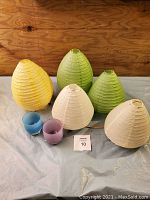 Overview photo showing the two Glassybaby candle holders in blue and purple along with five paper lantern lamps in yellow, green, and cream colors.