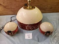 Overview photo showing large hanging lamp and two smaller Coors light domes on table