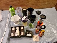 Photo of various small tea and coffee-related items including small cups, French press, coffee filter, drink bottles and decorative salt and pepper shakers.