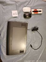 Wacom tablet, two computer mice and pen box arranged on a tarp