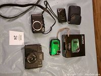 Lot overview showing five cameras and one camera case laid out on a surface.