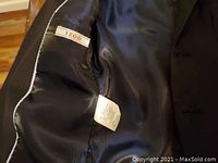 Close-up of interior black lining of one Izod jacket with label and care tag visible.