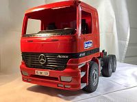 Front angled view of the red Bruder Mercedes Actros truck toy showing detailed front grill, Mercedes emblem, and side branding.