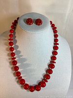 Front view of necklace and earrings set displayed on a mannequin bust showing bead details and earrings design.