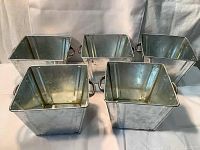 Five square tin buckets arranged in a group showing the top and side handles