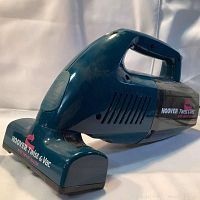 Side angled view of Hoover Twist & Vac handheld vacuum with swivel nozzle showing product name and model details.