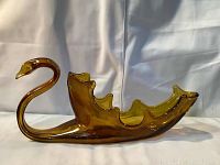 Side view of brown swirl glass swan bowl showing curved neck and body with scalloped bowl interior