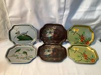 Photo of all six trays arranged in two rows of three, showing diverse painted decorative motifs with birds, peacocks, and flowers.