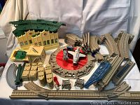 Overview of Thomas Trackmaster and Wooden Thomas Limited Edition set showing track pieces, buildings, and accessories including turntable and Carsen rubber airplane.