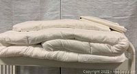 Folded white duvet cover and pillow shams stacked