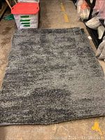 Full view of the dark grey shag carpet area rug laid flat on the floor, showing its rectangular shape and color tone.