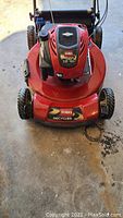 Front view of red Toro Recycler deck, engine housing, front wheels