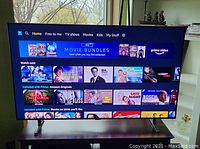 Front view of the TV powered on showing Amazon Prime Video home screen.