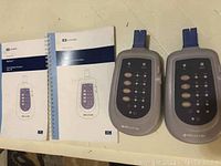 Two Nellcor SPO2 testers with their two manuals on a flat surface.