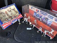 Both basketball and baseball Starting Lineup figures outside boxes arranged on black surface