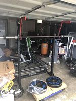 Assembled Rogue SPX squat rack with barbell and bumper plates in garage