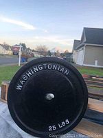 Front side of the weight plate showing raised white lettering 'WASHINGTONIAN' and '25 LBS'.
