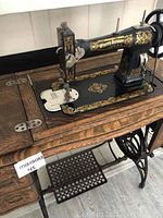 Full view of vintage White Rotary sewing machine on oak treadle cabinet base showing overall condition and one visible wheel present.