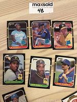Close-up image of seven individual 1987 Donruss MLB trading cards including rookies Bo Jackson, Mark McGwire, Greg Maddux, Bobby Bonilla, Barry Bonds, and Rafael Palmeiro laid out on a wooden surface.