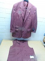 Frontal view of maroon Stacey Adams blazer and matching vest, both displayed against a brick wall