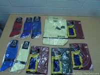Overview photo showing multiple pairs of socks and one yellow dress shirt laid flat on table.