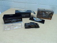 Overall view of Harley Davidson collectible black vintage car model parts with original tins and packaging