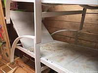 Side view of one metal frame chaise lounger with resin webbing showing dirt and dust.