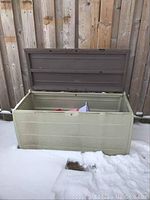 Closed resin deck box showing overall external condition and damage on front.