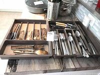 Photo showing all cutlery trays with mixed silver plate and stainless pieces.