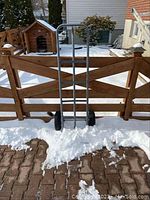 Hand truck dolly on brick patio with snow, showing full frame and tires