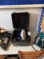 Open carrying case displaying the Smonize random orbit polisher with white polishing pad inside, showing tool details and condition.