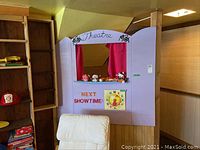 Front view of the entire puppet theatre with next showtime text and toy clock visible.